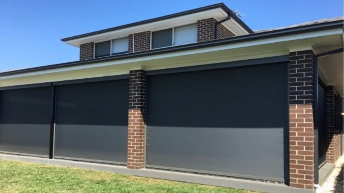 Zip screens covering large exterior windows on a modern home